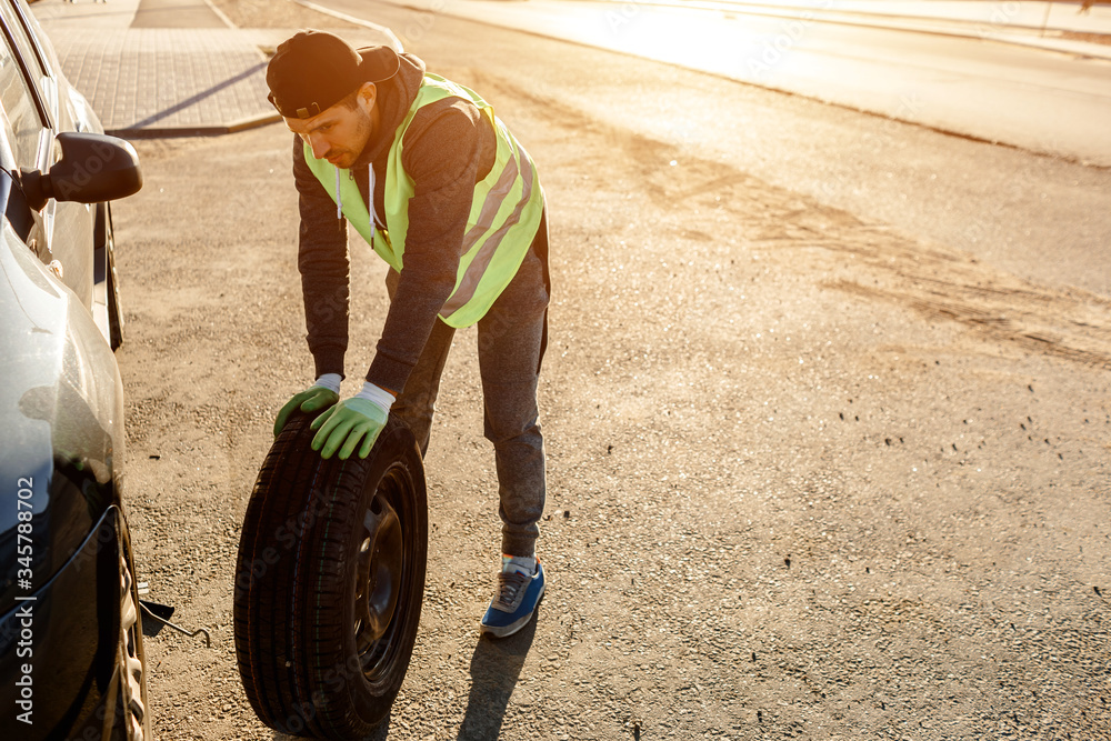 The driver should replace the old wheel with a spare. Man changing ...