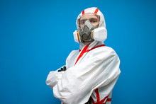 Professional Disinfector Man In A Protective Suit And A Respirator On A Blue Isolated Background, Disinfection Service Worker