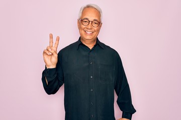 Sticker - Middle age senior grey-haired handsome man wearing glasses and elegant shirt smiling with happy face winking at the camera doing victory sign. Number two.