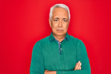 Poster - Middle age senior grey-haired man wearing casual sweater over red isoalted background skeptic and nervous, disapproving expression on face with crossed arms. Negative person.