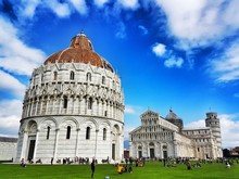 People At Piazza Dei Miracoli Against Blue Sky