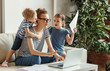 © JenkoAtaman - Stressed woman with kids working from home.