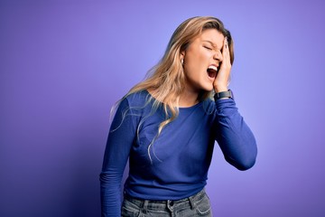 Canvas Print - Young beautiful blonde woman wearing casual t-shirt over isolated purple background Yawning tired covering half face, eye and mouth with hand. Face hurts in pain.