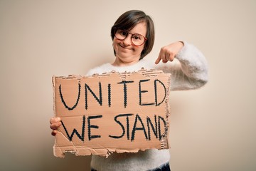 Sticker - Young down syndrome woman holding protest banner with united we stand rights message with surprise face pointing finger to himself