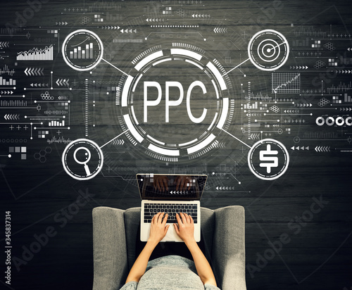 Fotomural PPC - Pay per click concept with person using a laptop in a chair