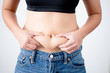 © PBXStudio - Woman holding excess fat on her belly on a white background