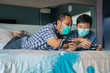 © Creativa Images - Little boy and father playing video game on the bed