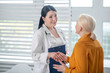 © zinkevych - Woman in white coat and patient shaking her hand.