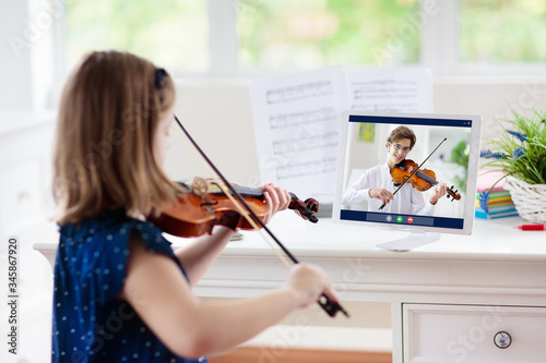 Fotografía Child playing violin. Remote learning.