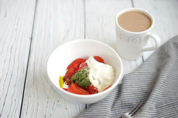 Sticker - Tomatoes, pesto and stracciatella cheese in a white bowl in the background
