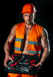 Male sexy builder in hardhat. Portrait of muscular man in standing on black background. Industrial architecture and construction.
