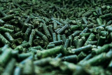 Wall Mural - a large number of alfalfa green granules in a warehouse for the production of agricultural feed