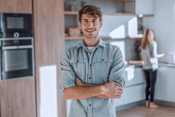 handsome young man standing in his kitchen.