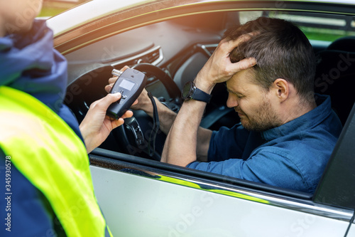 Fotomural drink and drive concept - sad drunk man sitting in the car after police alcohol