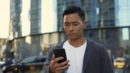 Left to right pan real time portrait shot of a man texting on the phone.