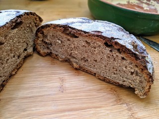 homemade round rye bread cut in half on a wooden Board