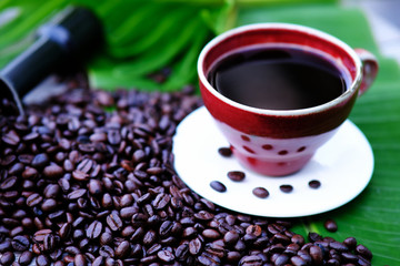 Coffee cup and coffee beans on wooden table background