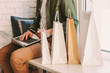 © Artem - Closeup young hipster man using laptop for online shopping and holding credit card in hand, sitting on windowsill with bags. Stylish man shopper buying at internet store from home. E-commerce, retail