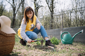 Woman digging with gardening tool in yard