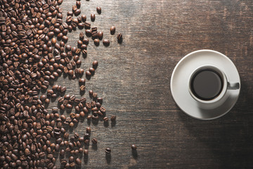 Wall Mural - Cup of coffee with coffee beans on old table