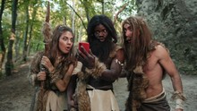 Ancient Neanderthals Tribe People Hunting In Forest Looking At Miracle Smartphone Rejoicing With Future Technology Growling Like Gorillas. Multi-ethnic Homo Sapiens.