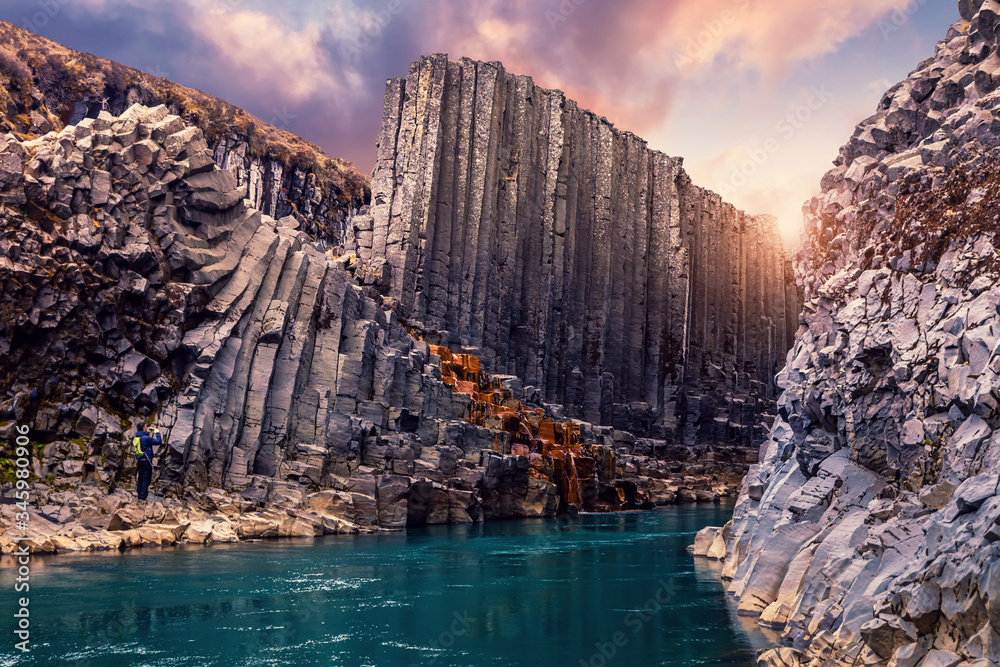 Amazing Nature landscape of Iceland. Impressively beautiful Studlagil canyon with basalt columns and colorful sky during sunset. Tipical Iceland scenery. Iconic location for photographers and bloggers - obrazy, fototapety, plakaty 