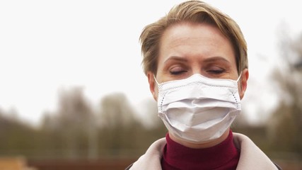 Wall Mural - health, safety and pandemic concept - young woman wearing protective medical mask outdoors