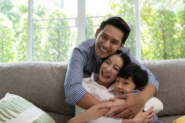 portrait of happy Asian family spending time together on sofa in living room. family and home concept.