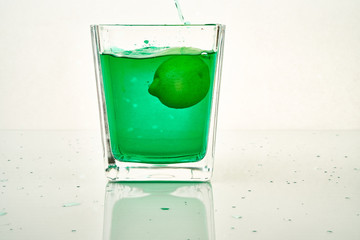 glass of green cocktail with lemon