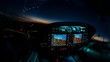 Lightened up cockpit and avionics in aircraft flying at night with beautiful twilight in background