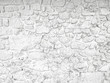 Old, whitewashed stone wall, painted white with peeling paint. Weathered background texture.