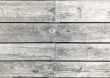Weathered horizontal wooden planks background, bleached white by the sun. Metal screws along center.
