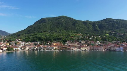 Canvas Print - Flying over the city of Salo, Lake Garda, Italy. Against the background of the historical part of the city, blue sky, mountains. Aerial view