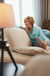 © puhhha - Mature Woman. Beautiful Healthy Middle Age Female Sitting On Sofa At Home. Beauty And Comfort Concept.