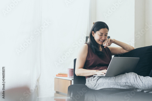 using computer.hand typing keyboard laptop online chatting search form internet while working sitting on sofa.concept for work from home.technology device contact communication business people