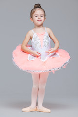 Wall Mural - Cute adorable ballerina little girl in pink tutu dance practices ballet dancing