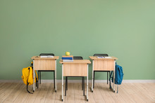 School Desks Near Color Wall In Classroom