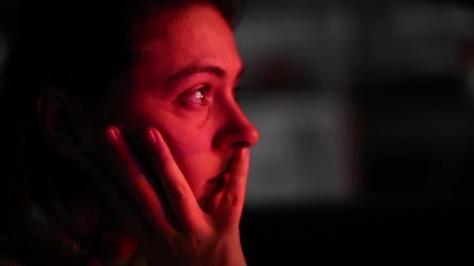 Wall Mural - Woman stopped in red light at night in city, red color on girl face waiting