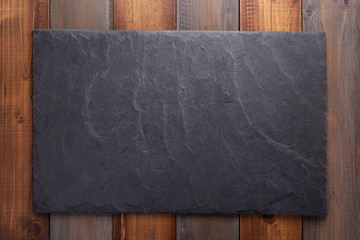 Wall Mural - black slate stone at wooden background