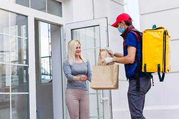 Courier with thermal backpack delivering fresh lunches to a young business woman. Takeaway restaurant food delivery concept