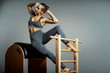 © Georgii - Pilates trainer exercises on a pilates barrel. Body training, perfect body shape and posture correction opporno motor apparatus. Copy space.