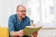 © contrastwerkstatt - Middle-aged man sitting reading a book