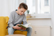 © contrastwerkstatt - Young teenage boy sitting reading a book