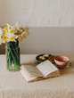 A cup of hot tea, flowers and book. Minimalist background. Vintage style