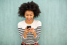 Happy Young African American Woman Looking At Phone Text Message By Green Background