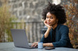 © mimagephotos - black businesswoman sitting with laptop computer