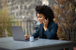 © mimagephotos - african american businesswoman sitting with laptop computer and mobile phone