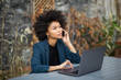 © mimagephotos - african american businesswoman using laptop computer and talking with cellphone