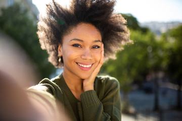 beautiful young african american woman taking selfie outdoors