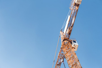 Construction crane tower site against a blue sky .  Cranes and building industry .